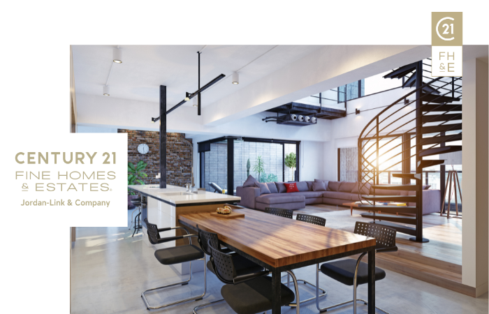 Spacious living area with high ceilings, modern furniture, exposed brick wall, and staircase, with Century 21 Fine Homes & Estates logo