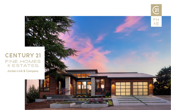 Modern home exterior at dusk with illuminated windows and landscaping, adorned with Century 21 Fine Homes & Estates logo